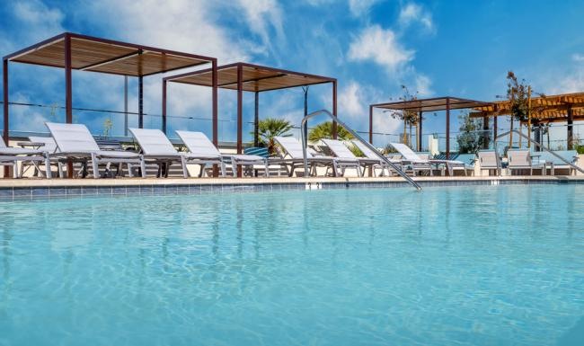 Shimmering resort-style pool a pool with chairs and a gazebo by it