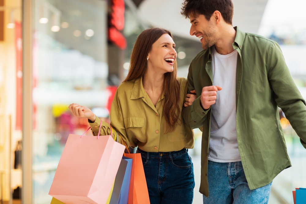 couple carrying shopping bags and laughing