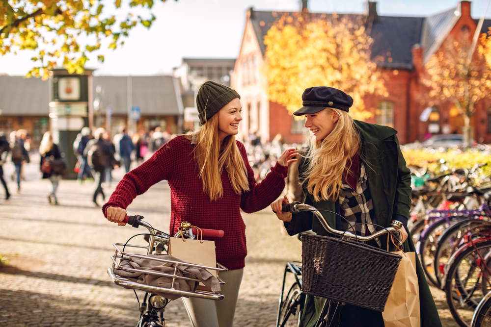 female friends shopping together and pushing their bicycles